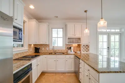 a kitchen with white cabinets and granite counter tops at 30A Beach House - Stillwater Cottage by Panhandle Getaways in Rosemary Beach