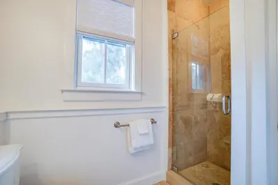 a bathroom with a shower and a toilet and a window at 30A Beach House - Stillwater Cottage by Panhandle Getaways in Rosemary Beach