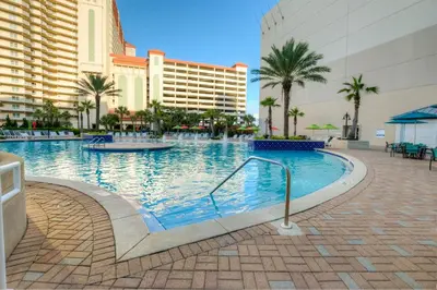 a swimming pool in a resort with palm trees and buildings at Next To The 10th Floor Pool - Laketown Wharf 1032- 2 BD Plus Bunks, 2BA, And Amazing Amenities! in Panama City Beach