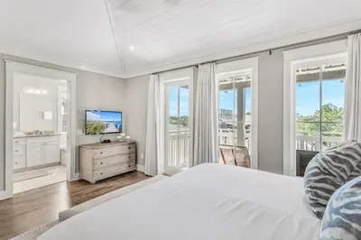 a white bedroom with a large bed and windows at Rolling Dunes in Inlet Beach
