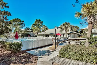 a house with a white fence and a wooden walkway at Beachwood Villas 6D- Beach Time Oasis in Santa Rosa Beach