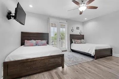 a bedroom with two beds and a flat screen tv at Blue Mermaid in Panama City Beach