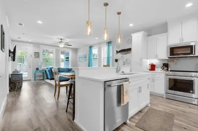 a kitchen with white cabinets and a kitchen island at Blue Mermaid in Panama City Beach