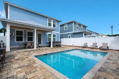 a swimming pool in front of a house at Blue Mermaid in Panama City Beach