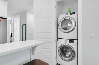 a white laundry room with a washer and dryer at Blue Mermaid in Panama City Beach