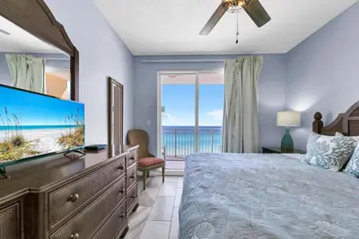 a bedroom with a bed and a large screen tv at Sterling Reef 401 in Panama City Beach