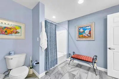 a blue bathroom with a toilet and a shower at Sterling Reef 401 in Panama City Beach