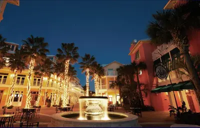 a courtyard with palm trees and a clock on a building at Sterling Reef 401 in Panama City Beach