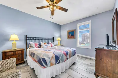 a bedroom with a bed and a ceiling fan at Sterling Reef 401 in Panama City Beach
