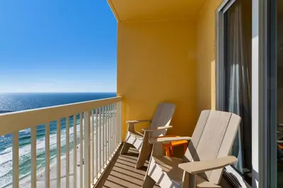 two chairs on a balcony with a view of the ocean at Calypso 1-2208 East in Panama City Beach