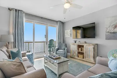 a living room with a couch and chairs and a tv at Calypso 1-2208 East in Panama City Beach