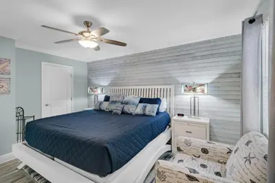a bedroom with a blue bed and a ceiling fan at Horizon South 74F in Panama City Beach