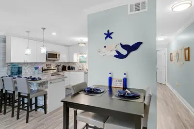 a kitchen and dining room with a table and chairs at Horizon South 74F in Panama City Beach