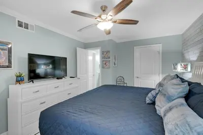 a bedroom with a bed and a flat screen tv at Horizon South 74F in Panama City Beach