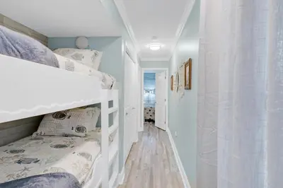 a childs bedroom with bunk beds and a hallway at Horizon South 74F in Panama City Beach