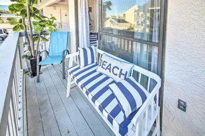 a pair of chairs sitting on a porch at PCB Condo Rental with Pool Access, Steps to Beach! in Panama City Beach