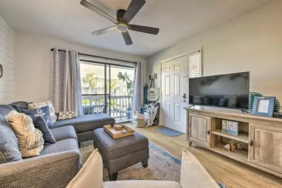 a living room with a couch and a flat screen tv at PCB Condo Rental with Pool Access, Steps to Beach! in Panama City Beach