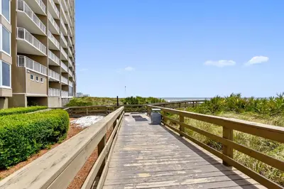 a boardwalk leading to the beach next to a building at Emerald Beach #1227 by Book That Condo in Panama City Beach