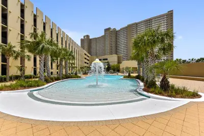 a fountain in the middle of a courtyard with palm trees at Emerald Beach #1227 by Book That Condo in Panama City Beach