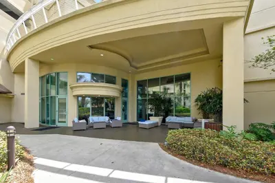 a large building with white couches in a courtyard at Emerald Beach #1227 by Book That Condo in Panama City Beach