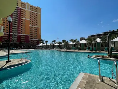 a swimming pool at a resort with blue water at Calypso 3-2303 Penthouse Level w/ Incredible View! in Panama City Beach