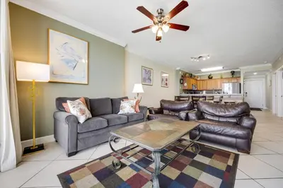 a living room with leather furniture and a ceiling fan at PARKING INCLUDED-Beachfront 2BD Ocean Villa! Gorgeous Amenities, Private Complex in Panama City Beach
