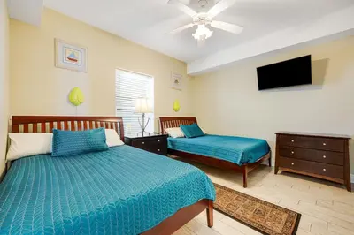 a bedroom with two beds and a flat screen tv at PARKING INCLUDED-Beachfront 2BD Ocean Villa! Gorgeous Amenities, Private Complex in Panama City Beach
