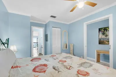 a bedroom with a bed and a ceiling fan at Polynesian Village 211 in Panama City Beach
