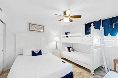 a bedroom with two bunk beds and a ceiling fan at Summerhouse 502A in Panama City Beach