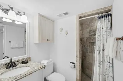 a white bathroom with a sink and a shower at Summerhouse 502A in Panama City Beach