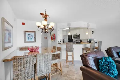 a dining room and kitchen with a table and chairs at Summerhouse 502A in Panama City Beach
