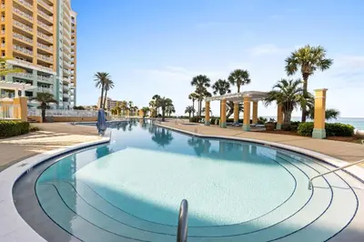 a swimming pool at a resort with palm trees at En Soleil Beach Resort by Panhandle Getaways in Panama City Beach