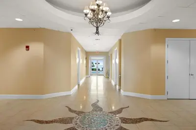 a hallway with a chandelier and a tile floor at En Soleil Beach Resort by Panhandle Getaways in Panama City Beach