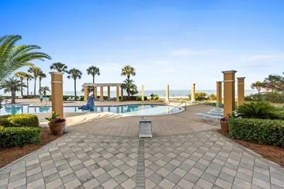 a swimming pool with palm trees and a resort at En Soleil Beach Resort by Panhandle Getaways in Panama City Beach