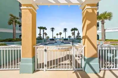 a balcony with a gate and palm trees at En Soleil Beach Resort by Panhandle Getaways in Panama City Beach