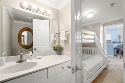 a white bathroom with a sink and a mirror at Summer By The Sea Unit 2203 in Panama City Beach