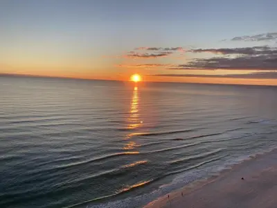 a sunset on the beach with the ocean at Summer By The Sea Unit 2203 in Panama City Beach