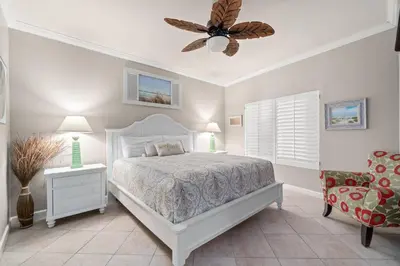 a bedroom with a white bed and a ceiling fan at Summer By The Sea Unit 2203 in Panama City Beach