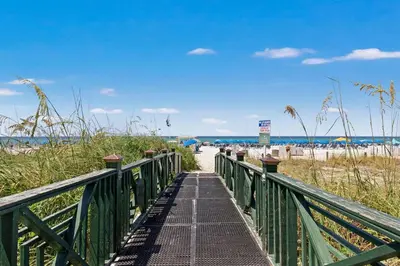 a boardwalk leading to a beach with the ocean at Grand Panama Beach Resort by Panhandle Getaways in Panama City Beach
