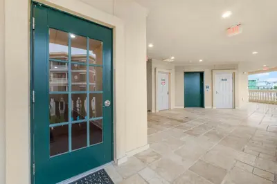 a hallway with a green door and a tile floor at 30A Villages of South Walton by Panhandle Getaways in Seacrest