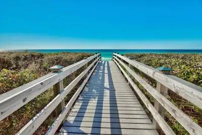 a boardwalk to the beach with the ocean in the background at 30A Villages of South Walton by Panhandle Getaways in Seacrest