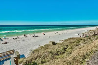 a group of people on a beach near the ocean at 30A Villages of South Walton by Panhandle Getaways in Seacrest