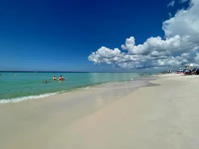 a group of people swimming in the ocean on a beach at Lullwater Condos 291 in Panama City Beach
