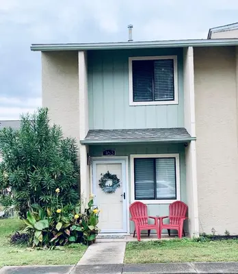 two red chairs sitting on the front door of a house at The Nest Egg in Panama City Beach