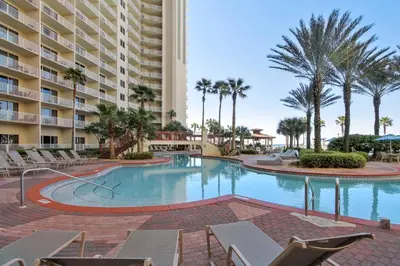 a swimming pool with chairs and a large building at Shores of Panama #124 by Book That Condo in Panama City Beach