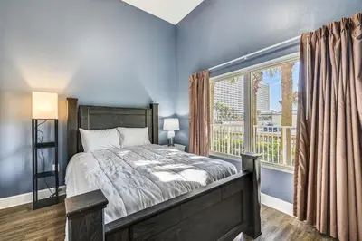 a bedroom with a bed and a large window at Shores of Panama #124 by Book That Condo in Panama City Beach