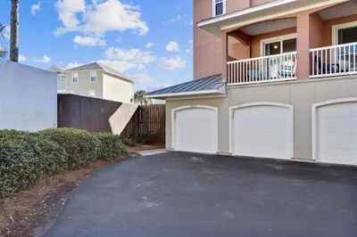 a house with white garage doors and a fence at Sunny Side Up by Book That Condo in Panama City Beach