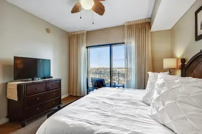 a bedroom with a bed and a flat screen tv at Origin at Seahaven #831 by Book That Condo in Panama City Beach