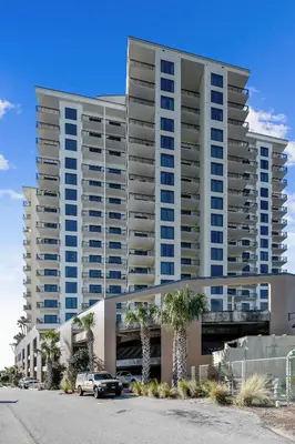 a large apartment building with cars parked in a parking lot at Origin at Seahaven #831 by Book That Condo in Panama City Beach