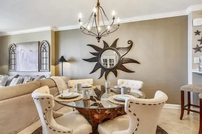 a dining room with a table and a couch at Tropic Winds Condominium #1405 by Book That Condo in Panama City Beach